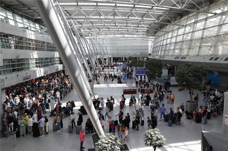 Winterflugplan: Düsseldorf und Köln bieten mehr Flüge  Reisende stehen im Flughafen Düsseldorf in langen Warteschlangen an der Gepäckabgabe. (Archivbild)David Young/dpa
