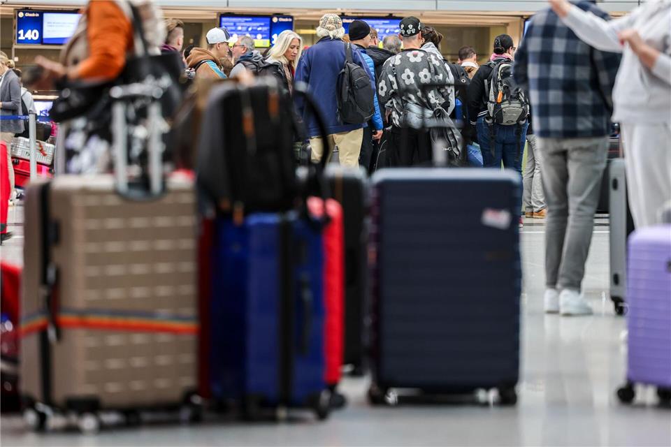 Reisende stehen mit Koffern im Abflugbereich. (Symbolbild)Christoph Reichwein/dpa