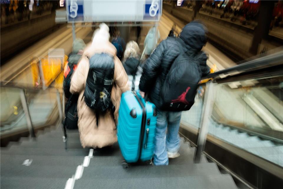 Reisende tragen auf dem Berliner Hauptbahnhof neben den gesperrten Rolltreppen große Koffer die Treppen hinab zum Bahnsteig. Carsten Koall/dpa