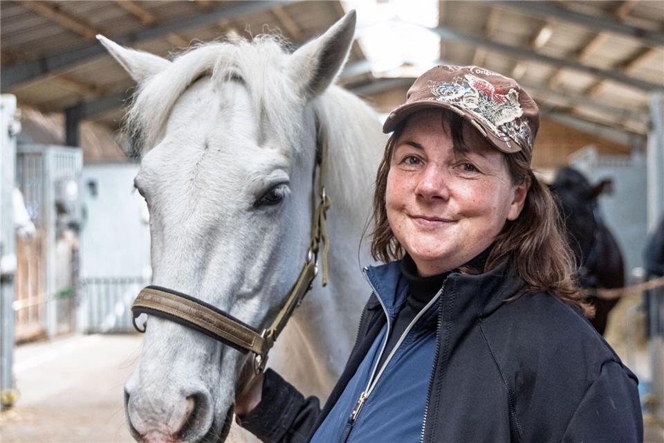 Reitstallchefin Sylvia Kassel steht mit dem Schimmel „Meloso“ im Pferdestall der Karl-May-Spiele auf dem Reiterhof Behnk.Markus Scholz/dpa