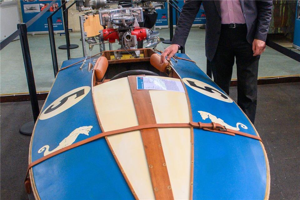 Rennbootfahrer und DDR-Meister Olaf Koenig steht im Technikmuseum Magdeburg neben einem Boot aus seiner Sammlung aus dem Jahr 1938. Klaus-Dietmar Gabbert/dpa