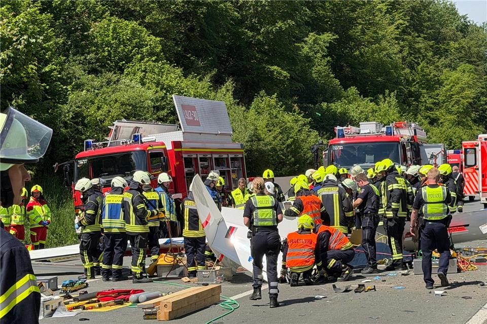 Rettungsdienste und Polizei arbeiten an der Unfallstelle, nachdem ein Segelflugzeug auf die A45 gestürzt ist. Berthold Stamm/dpa