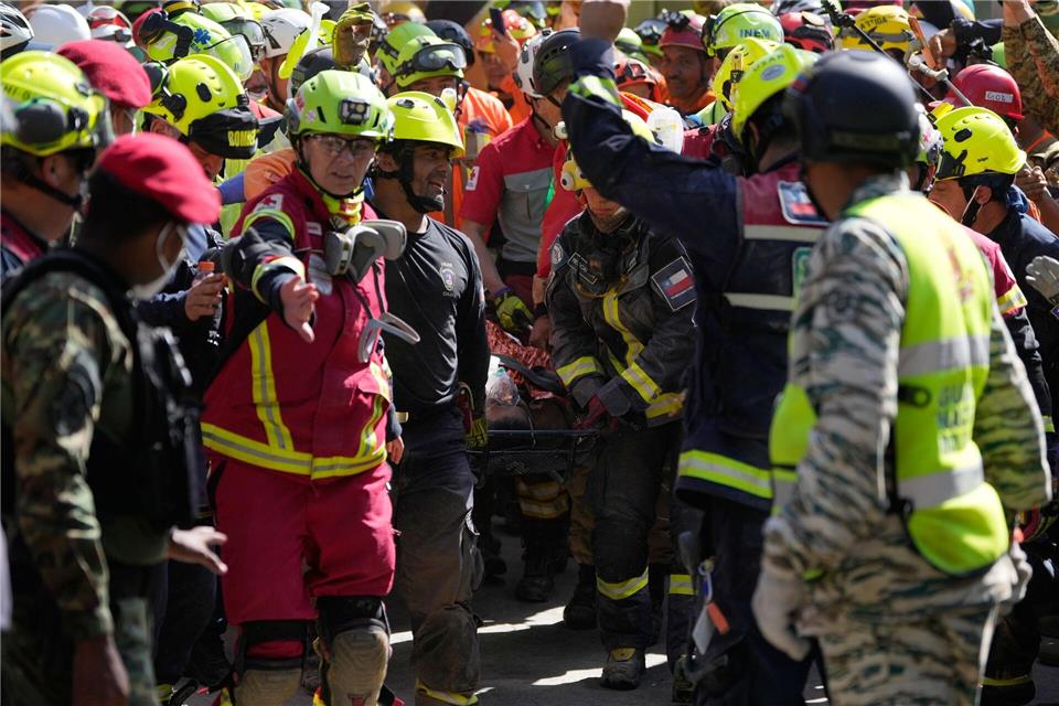 Rettungskräfte bergen einen Mann lebend aus den Trümmern eines eingestürzten Einkaufszentrums. Fernando Vergara/AP/dpa