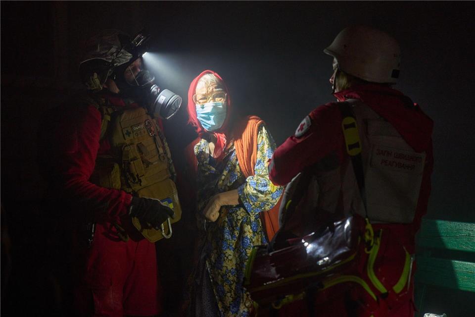 Rettungskräfte evakuieren eine ältere Bewohnerin nach dem Einschlag einer russischen Rakete in ein mehrstöckiges Wohnhaus außerhalb von Kiew.Efrem Lukatsky/AP/dpa