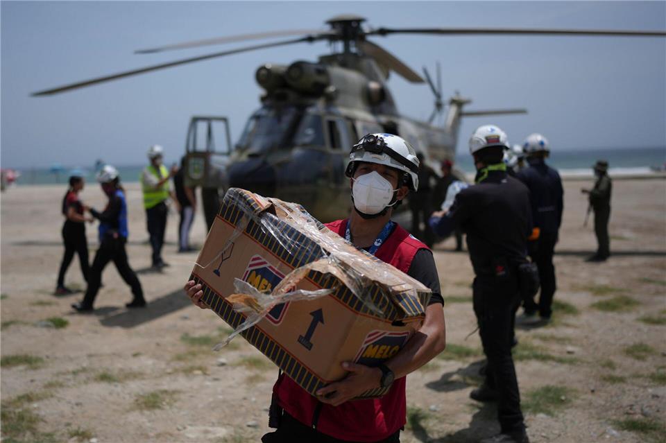 Rettungskräfte laden humanitäre Hilfsgüter für Erdbebenopfer in La Guaira in Venezuela ab.Matias Delacroix/AP/dpa