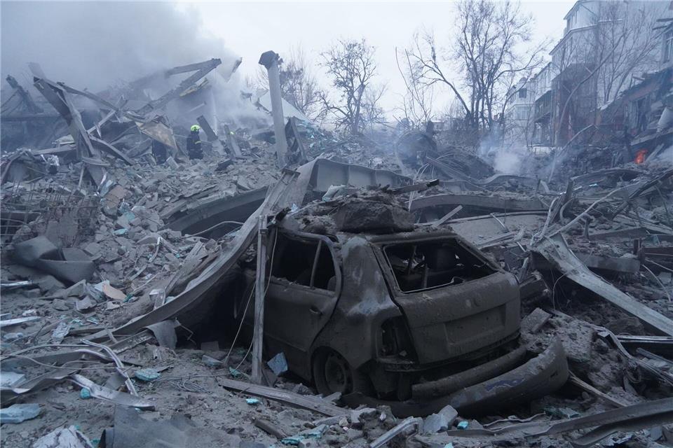 Rettungskräfte löschen einen Brand nach einem russischen Raketenangriff in Charkiw.Andrii Marienko/AP/dpa