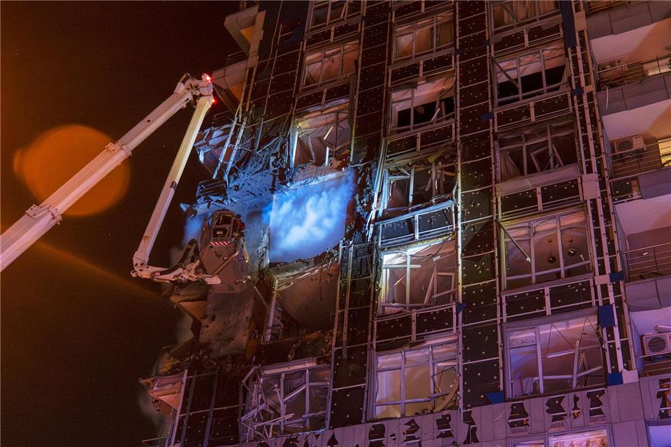 Rettungskräfte löschen in Kiew ein Feuer nach einem russischen Angriff.Dan Bashakov/AP/dpa