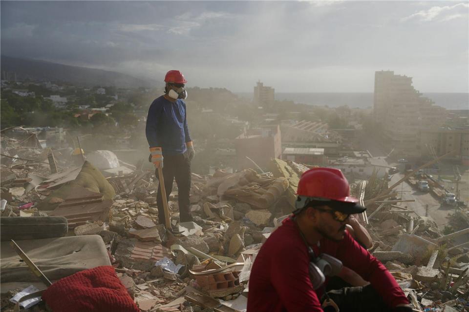 Rettungskräfte und Freiwillige durchsuchen die Trümmer eines Gebäudes, das bei den Erdbeben in Venezuela eingestürzt ist.Ariana Cubillos/AP/dpa