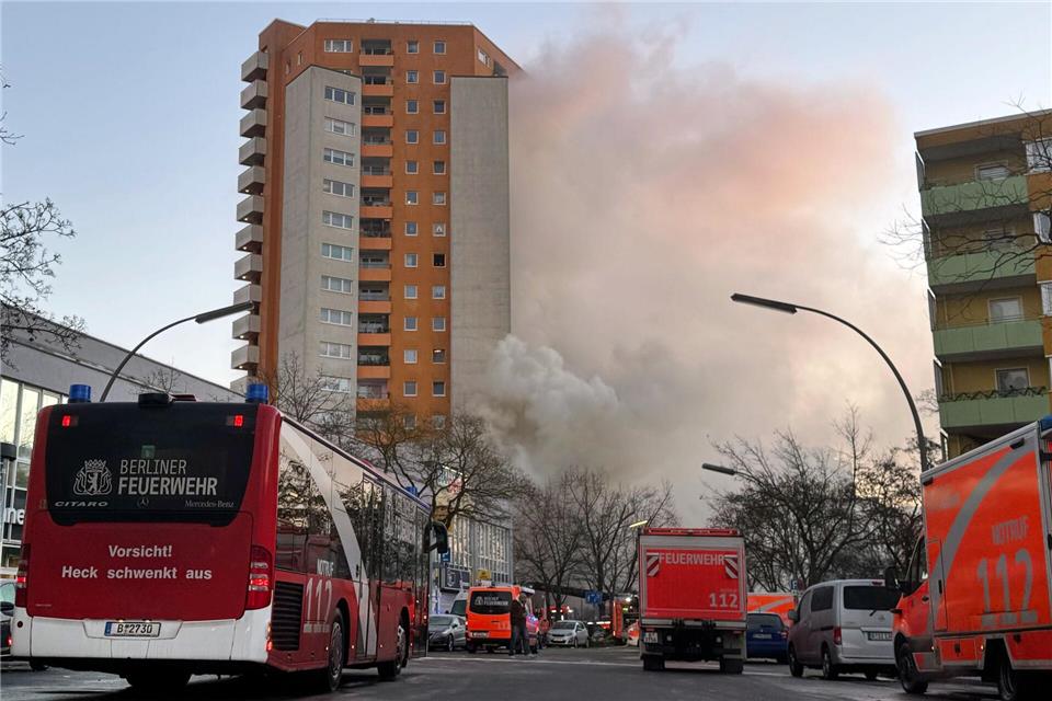 Rettungskräften vor dem brennenden Hochhaus in Berlin-Spandau. Sven Käuler/dpa