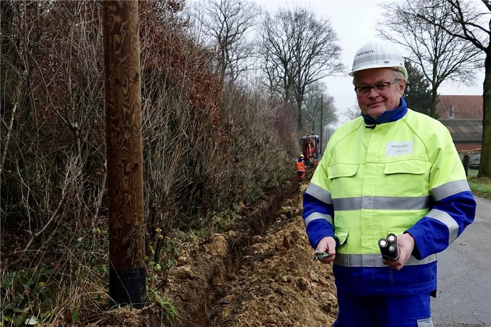 Richard Stegger zeigt die Freileitung (links) und das neue Erdkabel (rechts) an der Baustelle in Erle. Werschkull