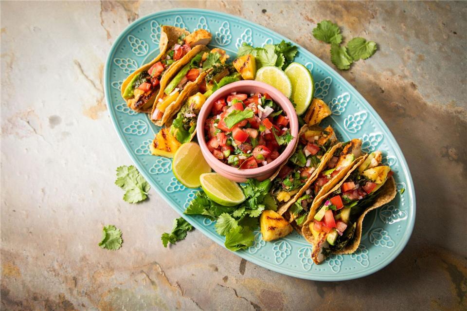 Richtig stilecht werden Hähnchen-Tacos erst mit Zugaben wie der mexikanische Tomatensalsa „Pico de Gallo“, argentinischer Kräutersauce „Chimichurri“, Avocado, gegrillter Ananas, Koriander und Limetten.Christin Klose/dpa-tmn