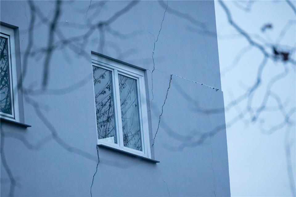 Rissen sind an der Fassade eines Mehrfamilienhauses zu sehen. Weil an mehreren Stellen der Boden abgesackt ist, ist das zweistöckige Haus einsturzgefährdet. (Archivbild)Henning Kaiser/dpa