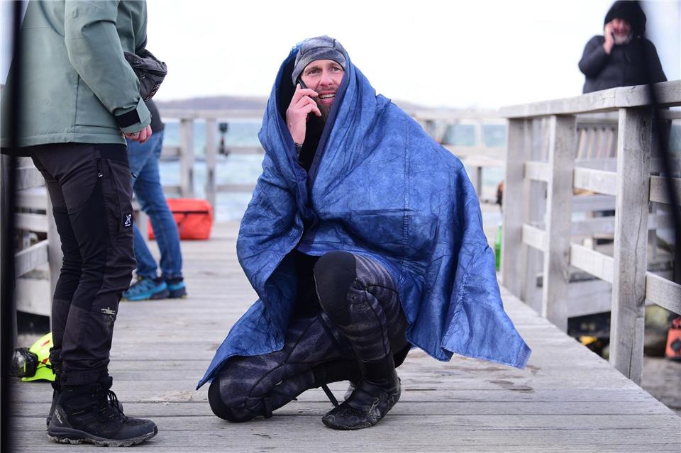 Robert Marc Lehmann geht auf Tuchfühlung mit einem gestrandeten Wal in der Ostsee. Daniel Bockwoldt/dpa