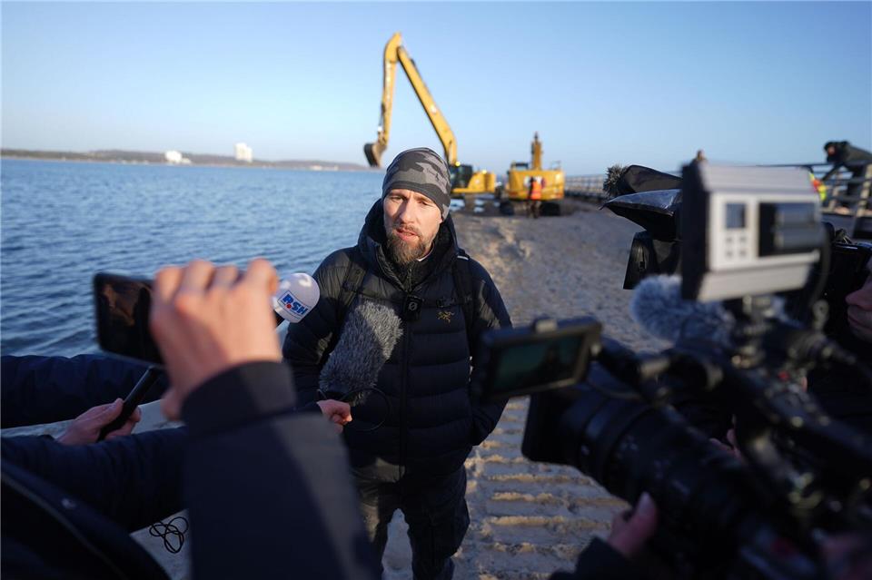 Robert Marc Lehmann spricht mit den Medien am Strand, in dessen Nähe der gestrandete Buckelwal im Wasser gelegen hatte.Marcus Brandt/dpa