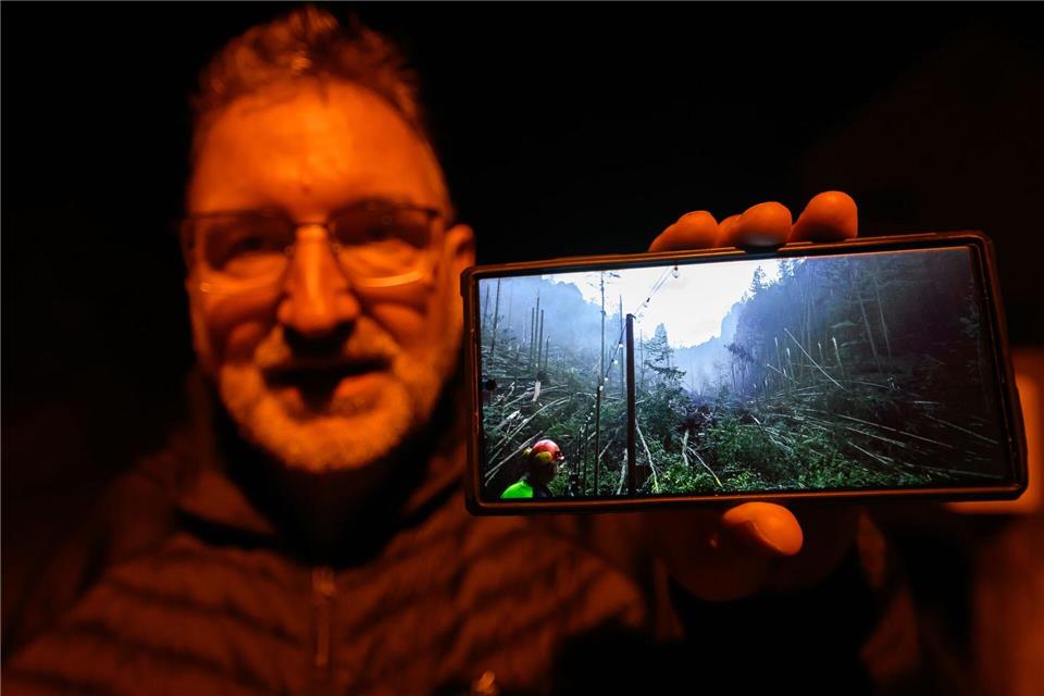 Roman Rolof, Bürgermeister von Rathen, zeigt nach schweren Unwettern ein Foto von Schäden auf seinem Smartphone, das er selbst aufgenommen hat.Robert Michael/dpa