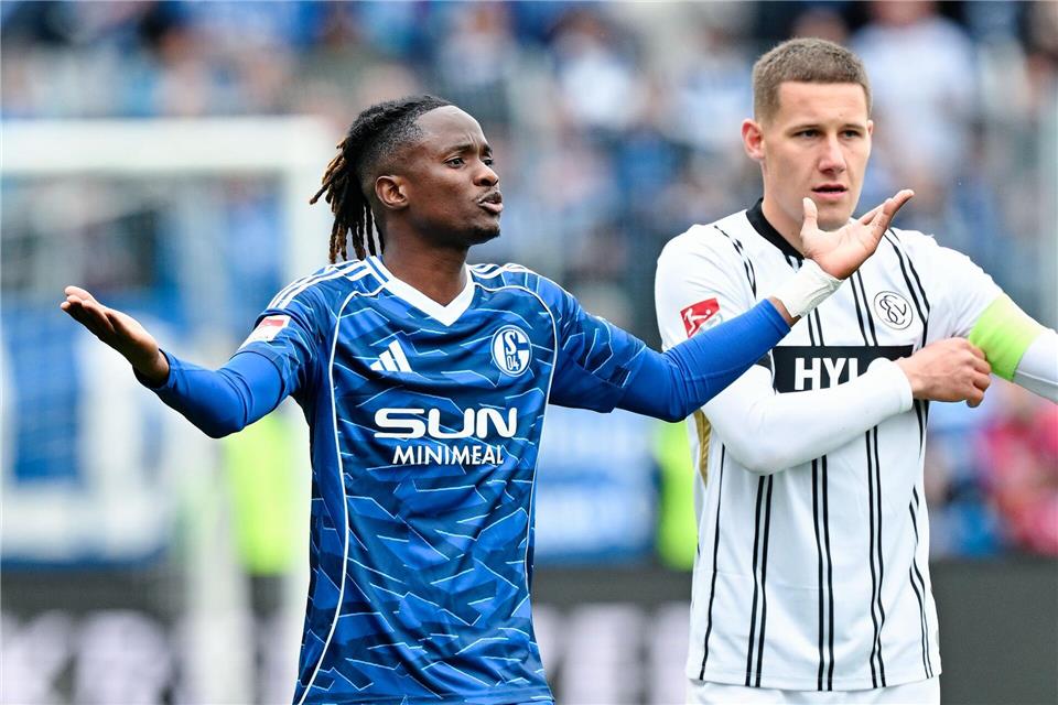 Schalkes Ndiaye (l) reagiert fassungslos auf seinen Platzverweis. Uwe Anspach/dpa