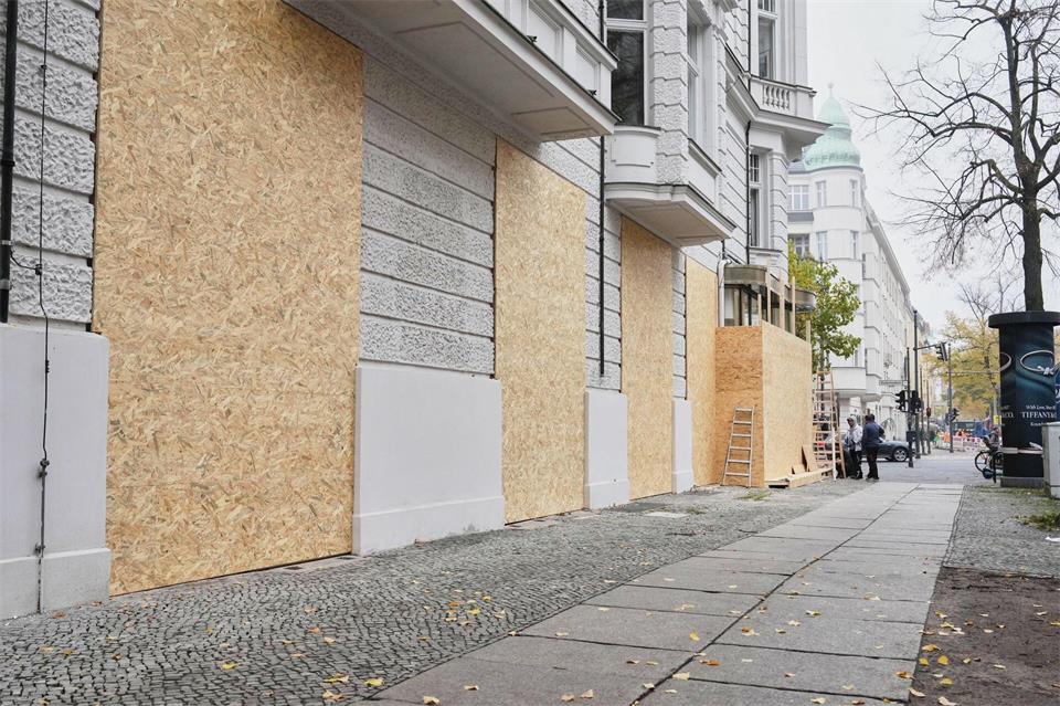 Schaufenster von Geschäften auf dem Kurfürstendamm werden aus Sorge über mögliche Ausschreitungen geschützt. Sven Kaeuler/dpa