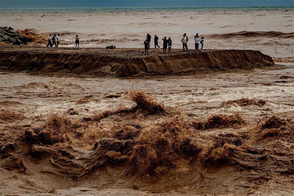 Schaulustige beobachten das aufgewühlte Wasser an der Mündung des Flusses Besòs nördlich von Barcelona.Jordi Boixareu/ZUMA Press Wire/dpa