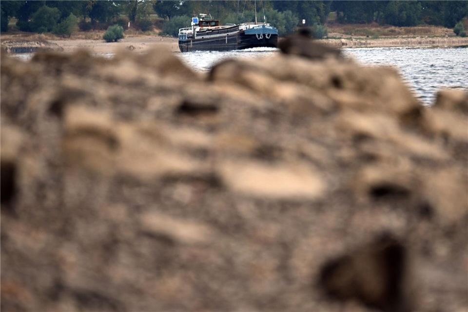Schiffe fahren an Steinen vorbei, die normalerweise unter der Wasseroberfläche liegen. Federico Gambarini/dpa