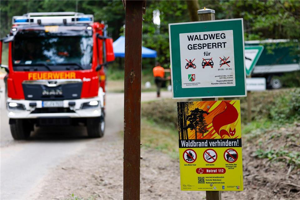 Schilder, die auf die Waldbrandgefahr und die Sperrung für Autos und Motorräder hinweisen, stehen an einem Waldweg.Thomas Banneyer/dpa