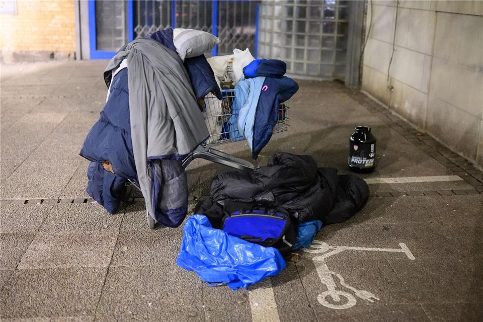Schlafsäcke, Decken und Kissen liegen in einem Einkaufswagen.Julian Stratenschulte/dpa