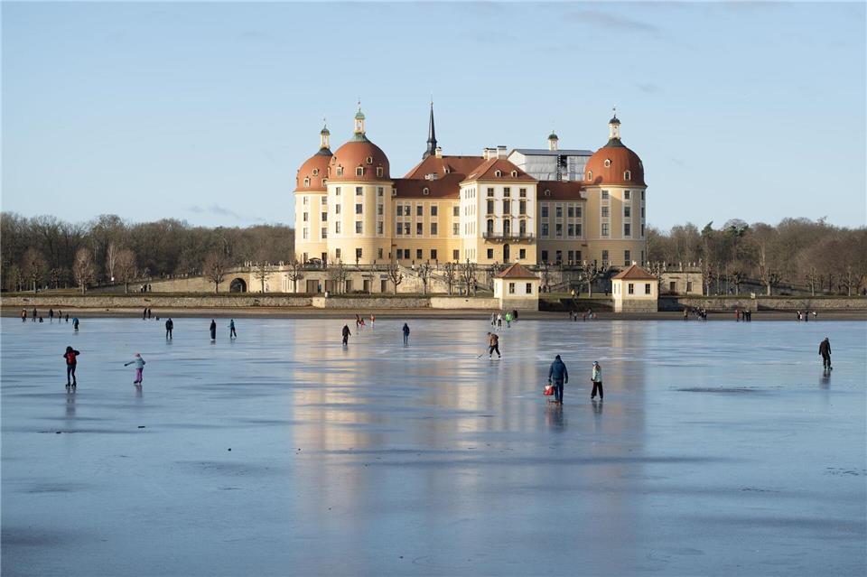 Schlittschuhläufer sind auf dem Eis vor Schloss Moritzburg in Sachsen unterwegs.Sebastian Kahnert/dpa