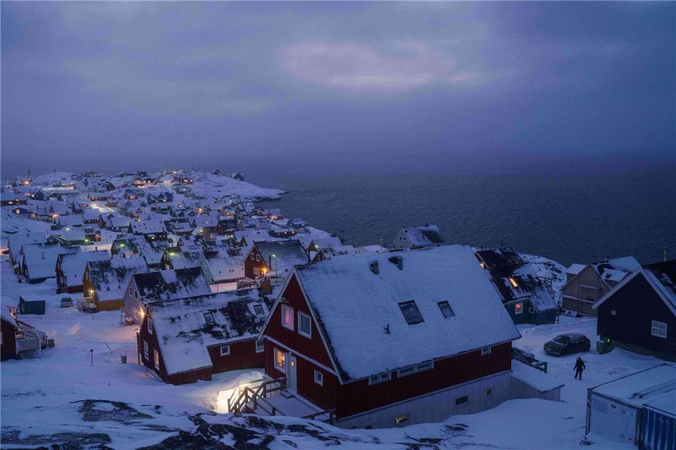 Schnee bedeckte Häuser stehen an der Küste einer Meeresbucht in Nuuk, der Hauptstadt von Grönland.Evgeniy Maloletka/AP/dpa
