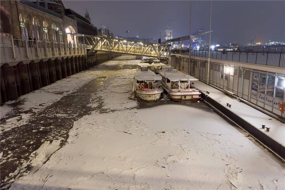 Schnee und Eis ist am späten Abend auf dem Wasser der Elbe in Hamburg zu sehen.Bodo Marks/dpa