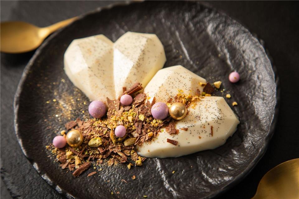 Schokolade, Pistazie, Goldstaub und Schokokugeln in Gold und Violett machen die Panna Cotta zum Highlight.Christin Klose/dpa-tmn