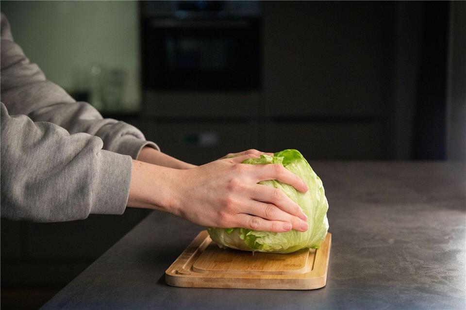 Schritt 1: Den Salat mit dem Strunk nach unten auf die Arbeitsfläche schlagen.Christin Klose/dpa-tmn