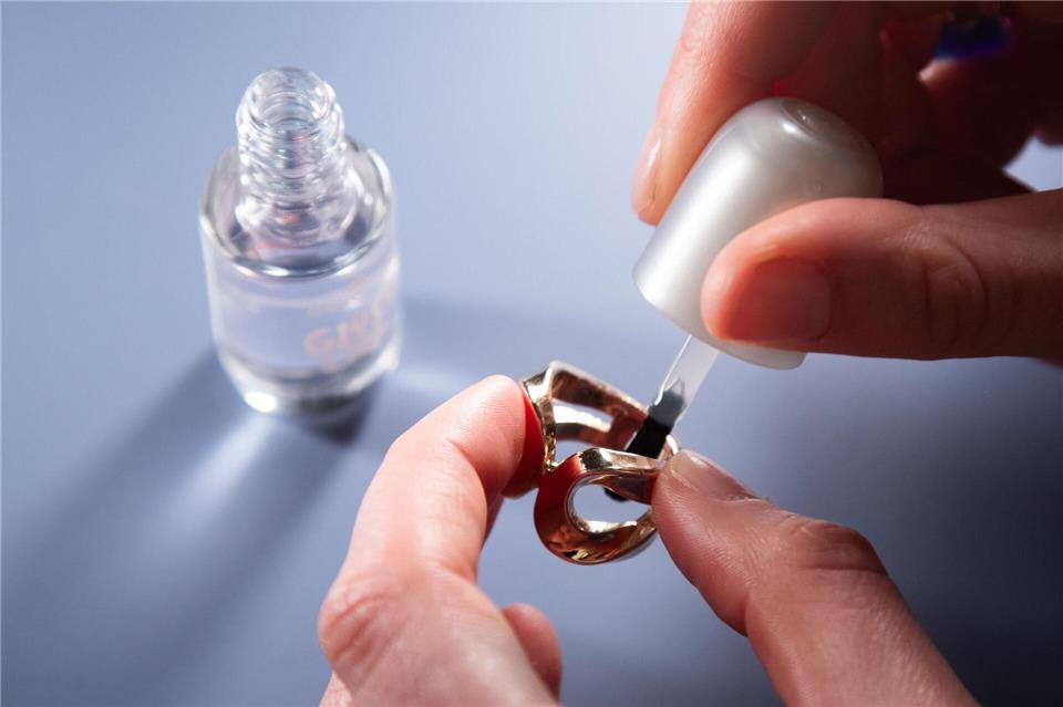 Schritt 1: Die Innenseite des Rings mit transparentem Nagellack bestreichen.Christin Klose/dpa-tmn