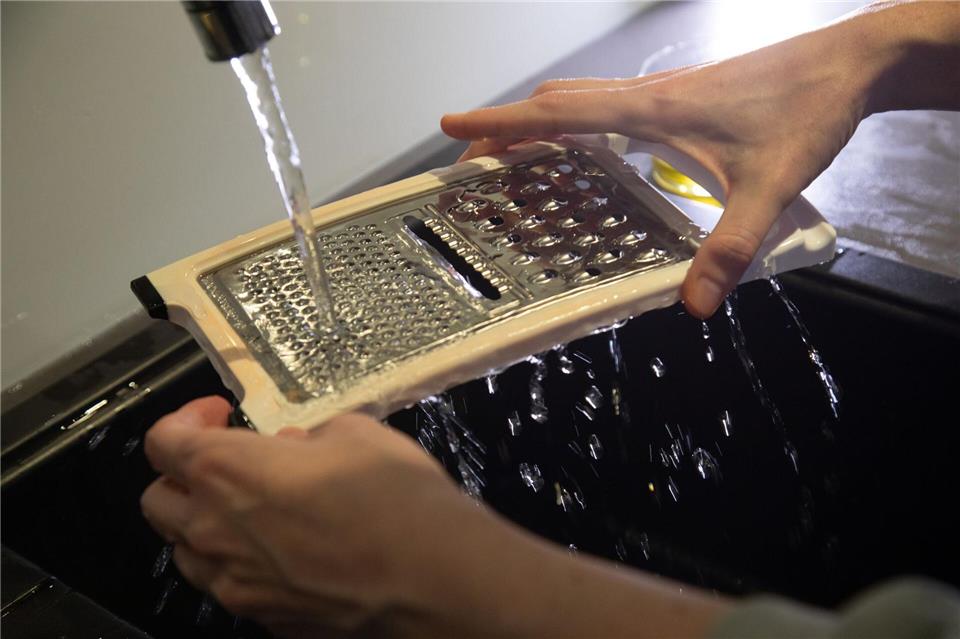 Schritt 1: Die Lebensmittelreste mit klarem Wasser entfernen.Christin Klose/dpa-tmn