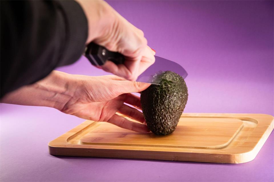 Schritt 2: Die Avocado auf das Schneidebrett legen und mit einem Messer längs rundherum bis zum Kern einschneiden.Christin Klose/dpa-tmn