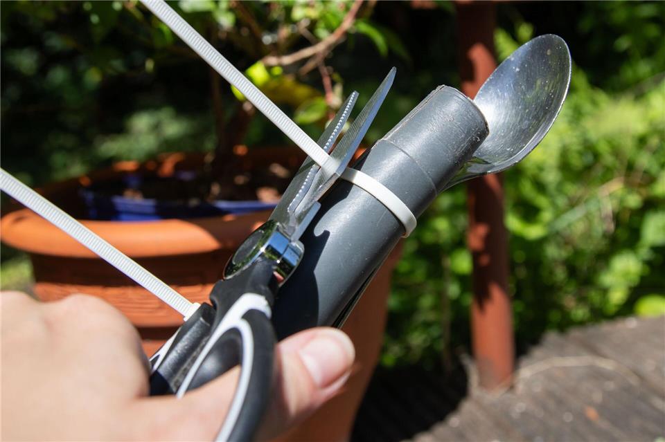 Schritt 2: Die überstehenden Enden des Kabelbinders mit der Schere abschneiden.Christin Klose/dpa-tmn