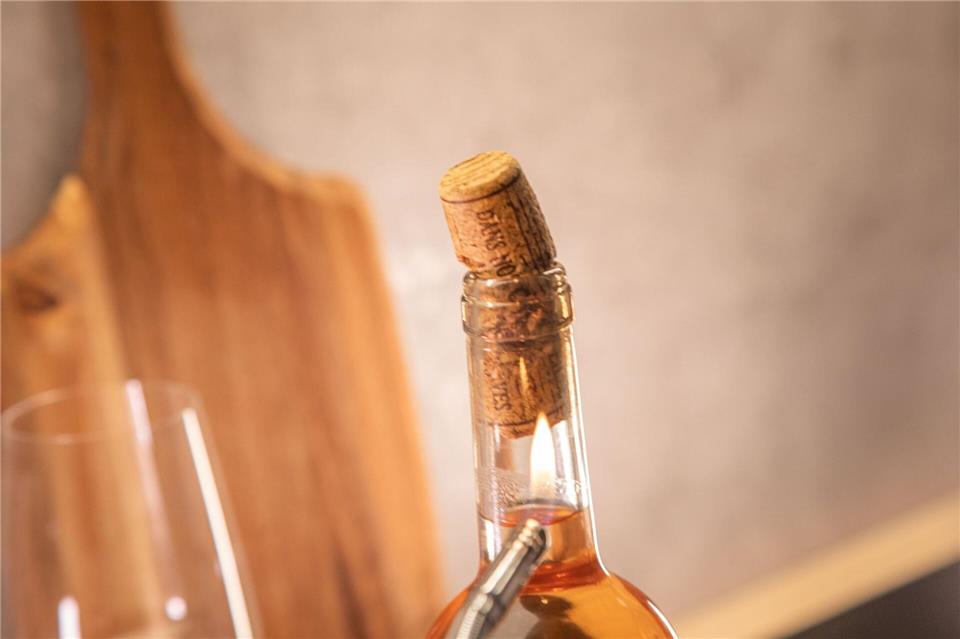 Schritt 2: Flaschenhals mit einem Feuerzeug erhitzen, bis der Korken aus der Flasche kommt.Christin Klose/dpa-tmn