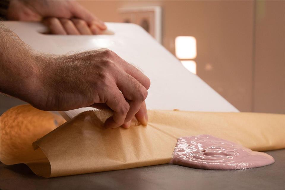 Ohne Wischen: Klecks restlos entfernen Schritt 2: Mit Hilfe des Schneidebretts den Joghurt auf das Backpapier schieben.Christin Klose/dpa-tmn