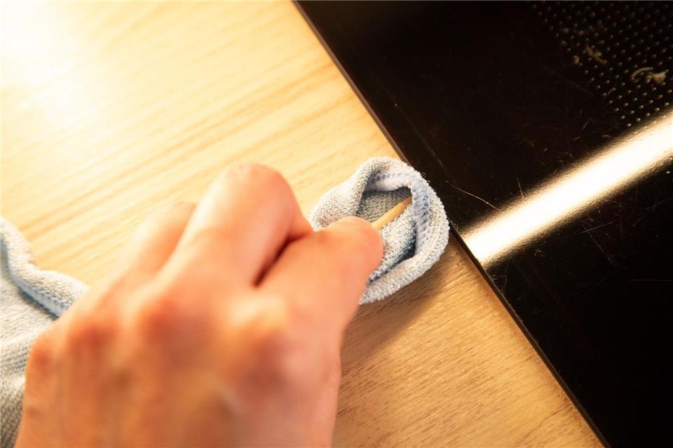 Schritt 2: Mit Spieß und Tuch unter dem Kochfeldrand entlangfahren.Christin Klose/dpa-tmn