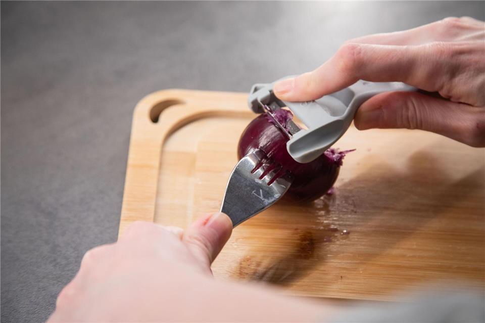 Schritt 2: Mit dem Schäler über die Zwiebel fahren.Christin Klose/dpa-tmn