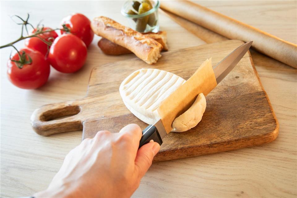 Schritt 2: Mit dem umwickelten Messer in den Käse schneiden.Christin Klose/dpa-tmn