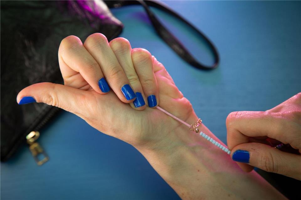 Armband anlegen ohne fremde Hilfe: So geht’s Schritt 3: Armband umlegen und mit den Fingern an der Haarnadel festhalten.Christin Klose/dpa-tmn