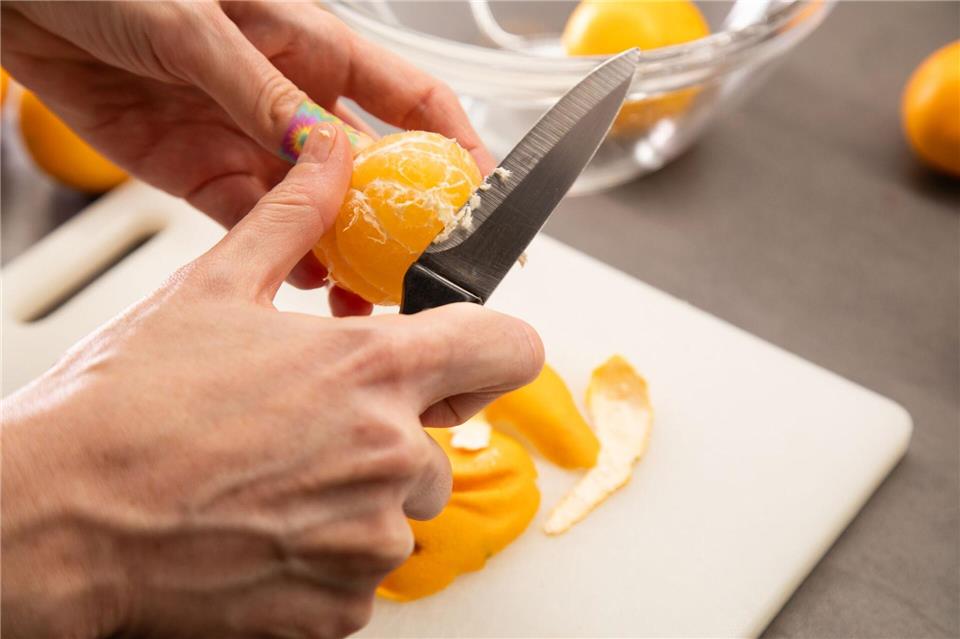 Schritt 3: Clementine mit einem Messer von den weißen Fäden befreien.Christin Klose/dpa-tmn