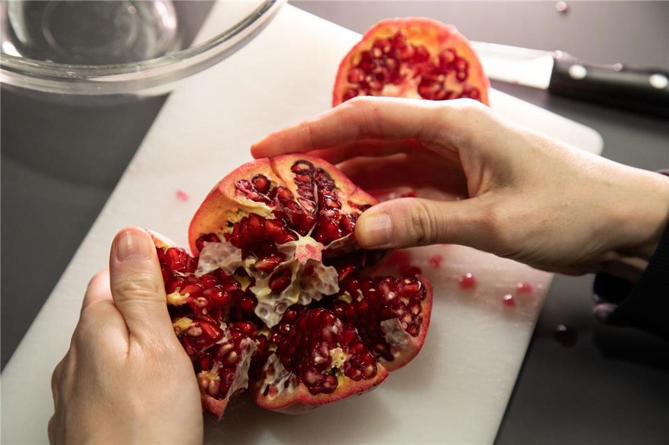 Schritt 3: Den Granatapfel auseinanderziehen und öffnen.Christin Klose/dpa-tmn