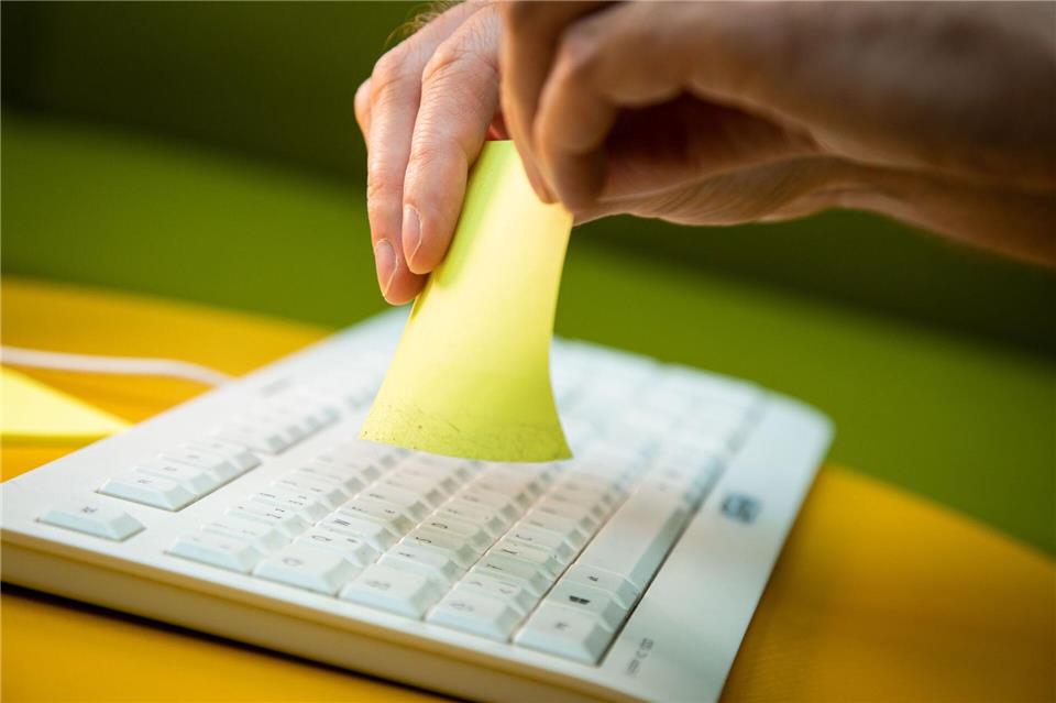 Tastatur reinigen mit einfachem Trick - so geht’s Schritt 3: Die Klebeseite umdrehen und durch dieselbe Tastenzeile noch einmal ziehen.Christin Klose/dpa-tmn