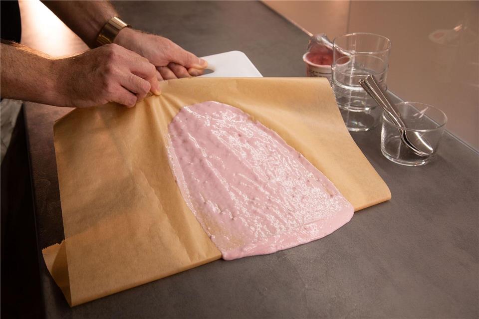 Ohne Wischen: Klecks restlos entfernen Schritt 3: Schneidebrett schieben und Backpapier ziehen, bis der Klecks vollständig aufgenommen wurde.Christin Klose/dpa-tmn