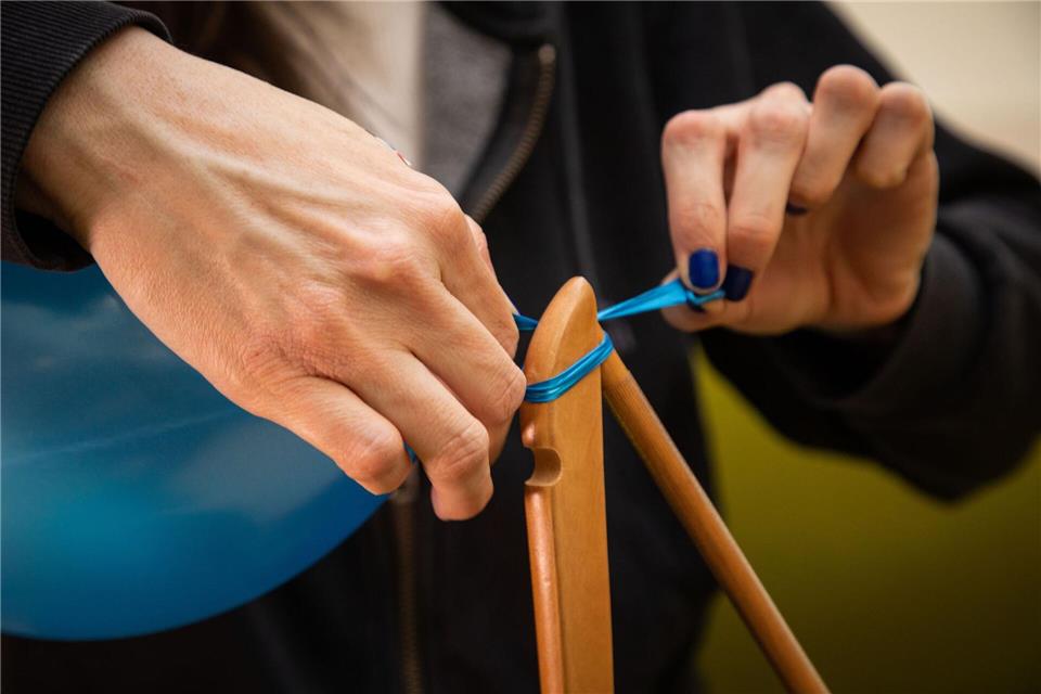 Schritt 5: Das verknotete Ende vom Kleiderbügel ziehen, bis der Ballon abrutscht.Christin Klose/dpa-tmn