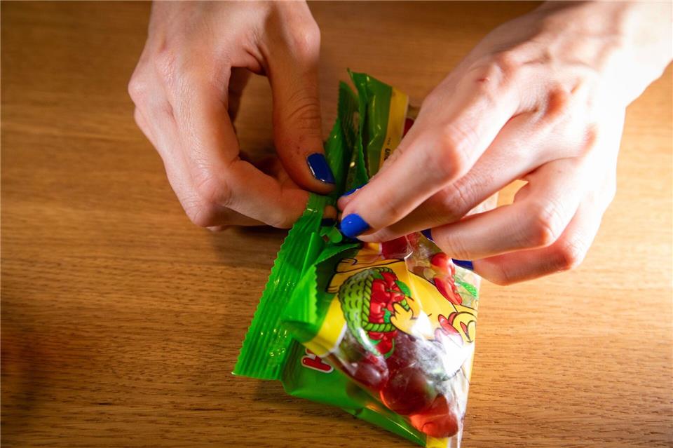 Fruchtgummi-Tüte dank Trick clever öffnen und verschließen? Schritt 6: Tüte umdrehen und das Band durch die Öffnung der Lasche fädeln.Christin Klose/dpa-tmn