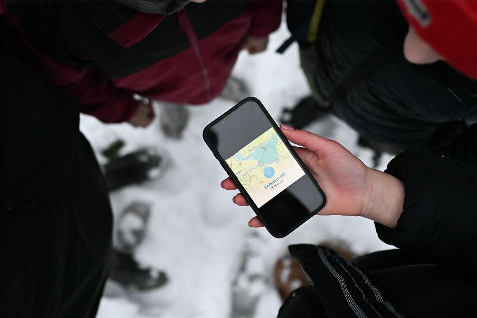 Schüler blicken auf ein Smartphone, das den Schulausfall für den Landkreis Leer anzeigt.Lars Penning/dpa