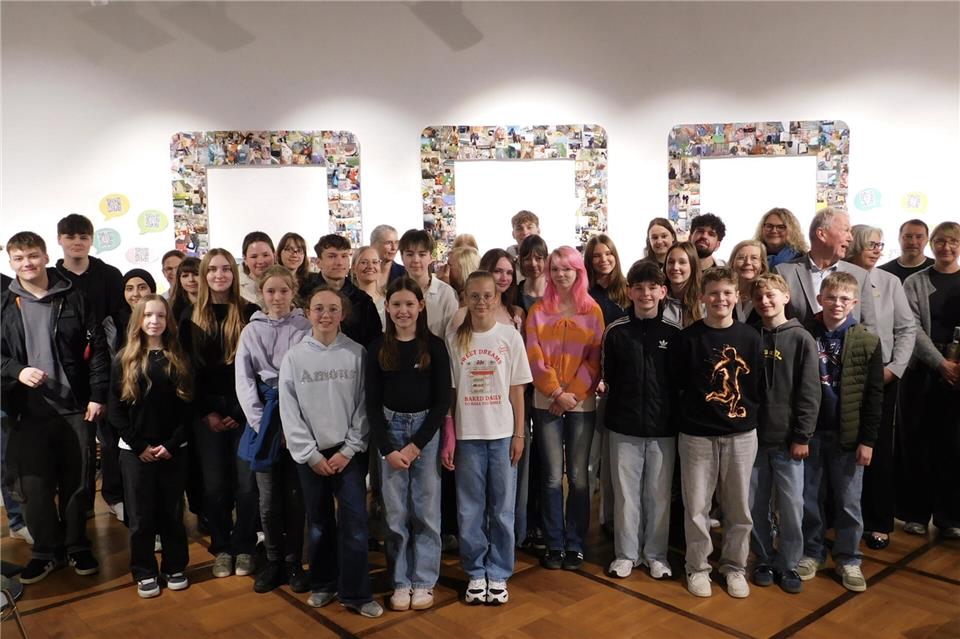 Schüler und Lehrer bei der Ausstellungseröffnung vor der Collage „800 gute Taten für Borken“ von der Schönstätter Marienschule.