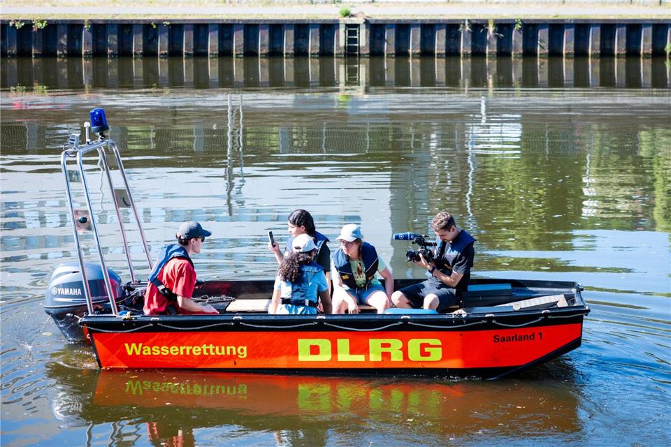 Schülerinnen und Schüler aus Saarbrücken sitzen in einem Rettungsboot der DLRG auf der Saar.Laszlo Pinter/dpa