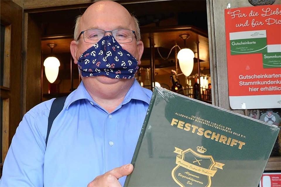 Schützenpräsident Arno Brömmel präsentiert die Festschrift – in Corona-Zeiten natürlich mit Maske.